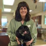 Veterinary technician holding her dog with tongue out