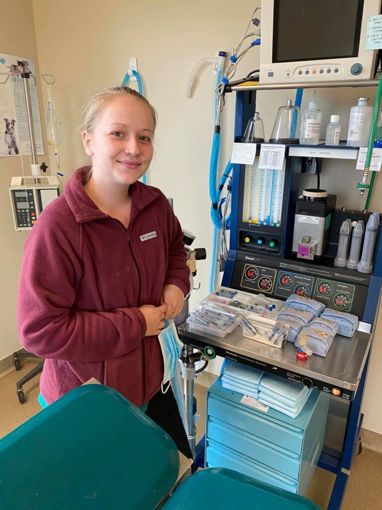 woman smiling standing next to anesthesia equipment