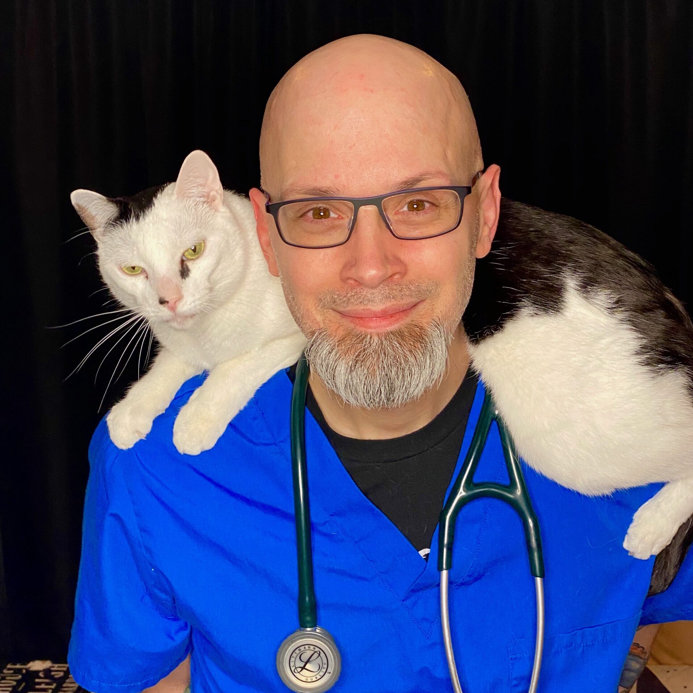 Man smiling with cat sitting on his shoulder