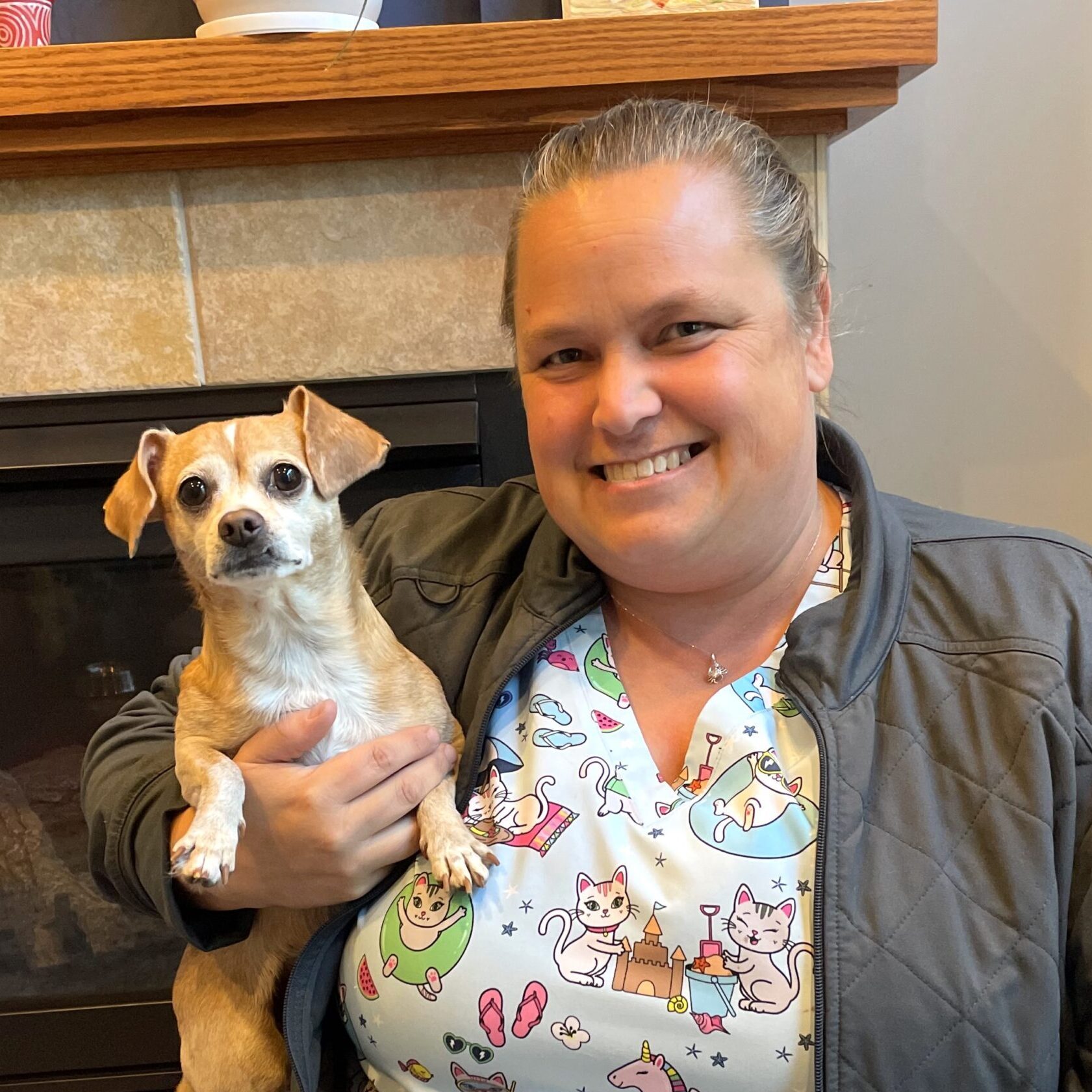 woman smiling holding a small dog