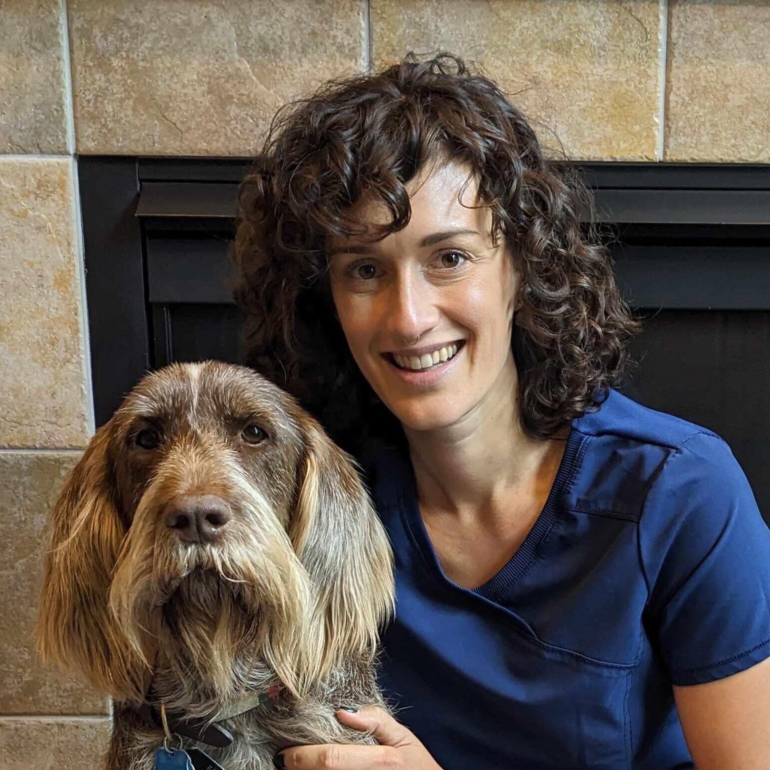 woman smiling sitting next to dog