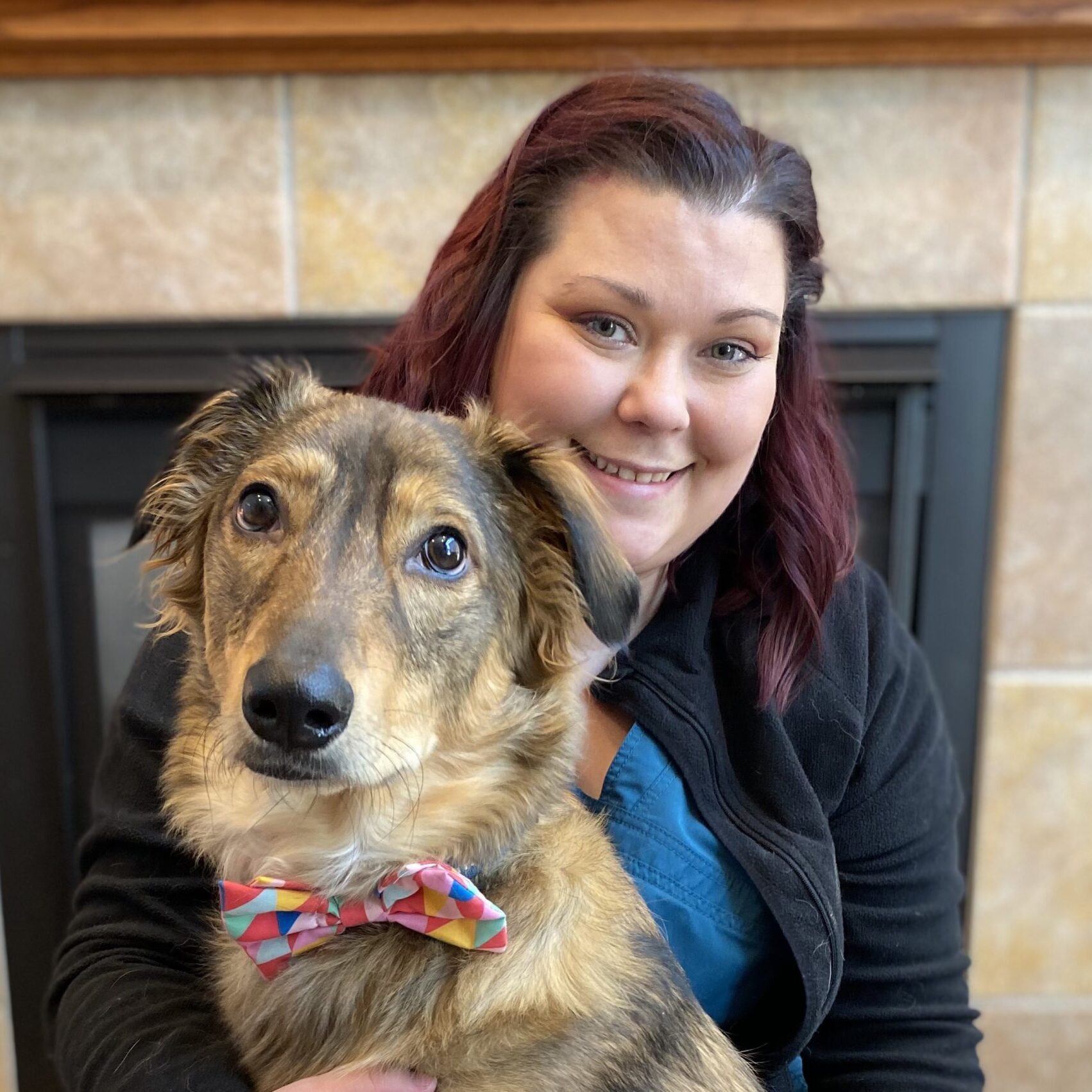 woman smiling with dog wearing bowtie