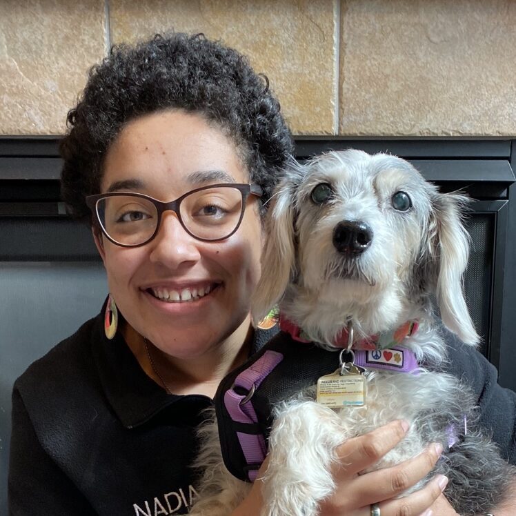 woman smiling and holding a dog